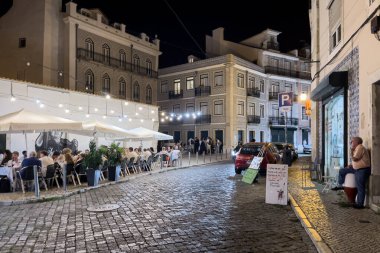 Geceleyin Lizbon caddesinde yürüyen bir kalabalık.