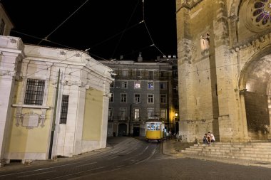 Geceleri Lizbon 'daki Aziz Mary Katedrali' nin önünden geçen eski bir tramvay.