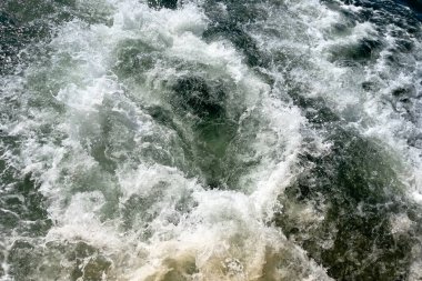 Hareketli bir tekneden güçlü dalgalar vuruyor.