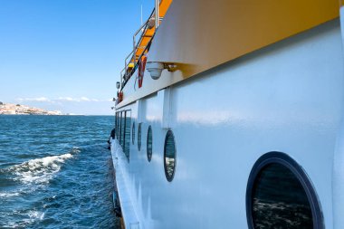 Lizbon şehrinin üzerinde manzaralı, denizde yüzen bir feribotun dış yüzeyi.