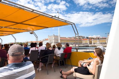 Bir grup turist Lizbon 'da bir tur teknesine biniyor.