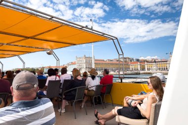 Bir grup turist Lizbon 'da bir tur teknesine biniyor.