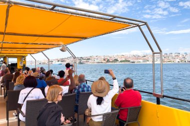 Bir grup turist Lizbon 'da bir tur teknesine biniyor.