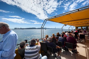 Bir grup turist Lizbon 'da bir tur teknesine biniyor.