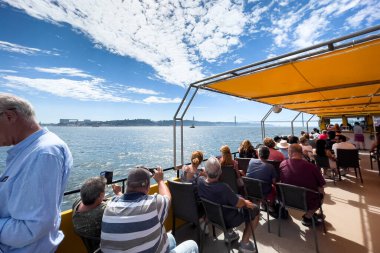 Bir grup turist Lizbon 'da bir tur teknesine biniyor.