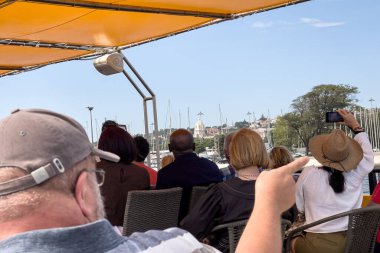 Bir grup turist Lizbon 'da bir tur teknesine biniyor.