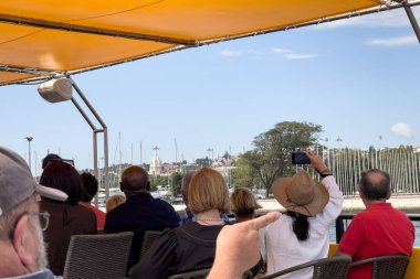 Bir grup turist Lizbon 'da bir tur teknesine biniyor.