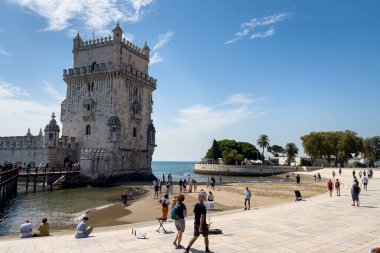 Lizbon 'da Belem kulesinin yakınında yürüyen turistler
