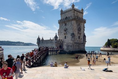 Lizbon 'da Belem kulesinin yakınında yürüyen turistler
