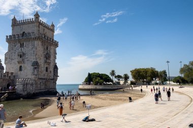 Lizbon 'da Belem kulesinin yakınında yürüyen turistler