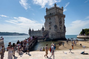 Lizbon 'da Belem kulesinin yakınında yürüyen turistler