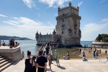 Lizbon 'da Belem kulesinin yakınında yürüyen turistler