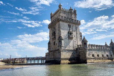 Lizbon 'da Belem kulesinin yakınında yürüyen turistler