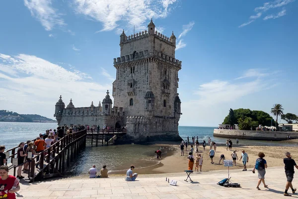 Lizbon 'da Belem kulesinin yakınında yürüyen turistler