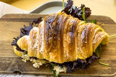 Masadaki içi doldurulmuş kruvasanın yakın çekimi.