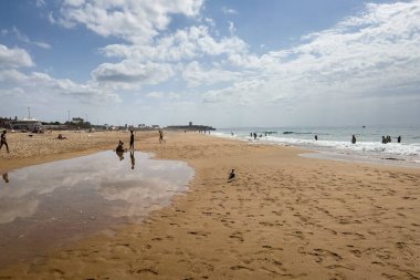 İnsanlar Carcavelos, Portekiz sahillerinde eğleniyorlar.