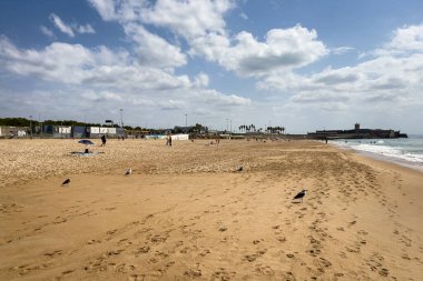 İnsanlar Carcavelos, Portekiz sahillerinde eğleniyorlar.