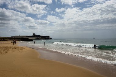 İnsanlar Carcavelos, Portekiz sahillerinde eğleniyorlar.