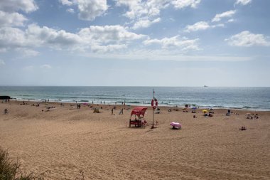 İnsanlar Carcavelos, Portekiz sahillerinde eğleniyorlar.