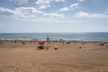 İnsanlar Carcavelos, Portekiz sahillerinde eğleniyorlar.