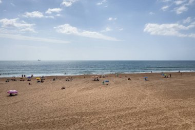 İnsanlar Carcavelos, Portekiz sahillerinde eğleniyorlar.