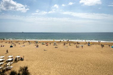 İnsanlar Carcavelos, Portekiz sahillerinde eğleniyorlar.