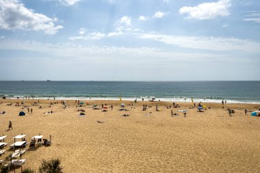 İnsanlar Carcavelos, Portekiz sahillerinde eğleniyorlar.