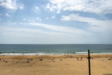 İnsanlar Carcavelos, Portekiz sahillerinde eğleniyorlar.