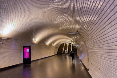Lizbon 'daki metro istasyonunda koridorun sonuna doğru yürüyen insanlar.