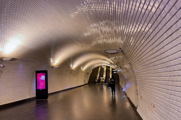 Lizbon 'daki metro istasyonunda koridorun sonuna doğru yürüyen insanlar.