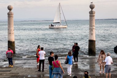Lizbon 'da bir tekne rampasında duran insanlar.