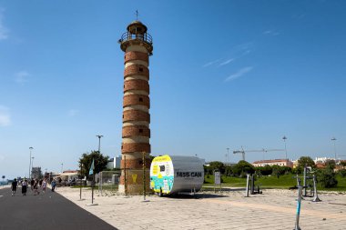 Lizbon 'daki Belem Deniz Feneri yakınlarında yürüyen turistler