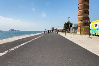 Lizbon 'daki Belem Deniz Feneri yakınlarında yürüyen turistler