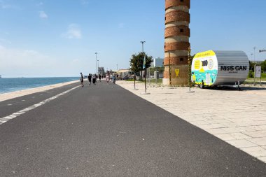 Lizbon 'daki Belem Deniz Feneri yakınlarında yürüyen turistler