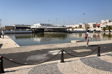 Lizbon 'daki Tagus nehrinin kıyısında yürüyen bir grup turist