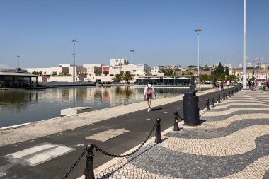 Lizbon 'daki Tagus nehrinin kıyısında yürüyen bir grup turist