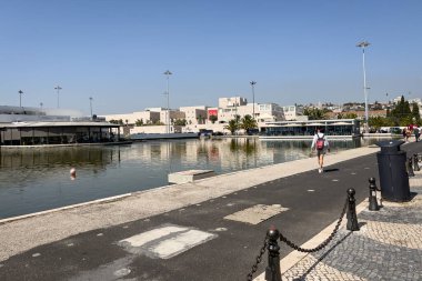 Lizbon 'daki Tagus nehrinin kıyısında yürüyen bir grup turist