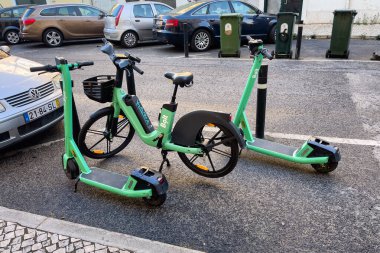 Lizbon 'da yolda park etmiş iki tane e-motosikletli mobilet.