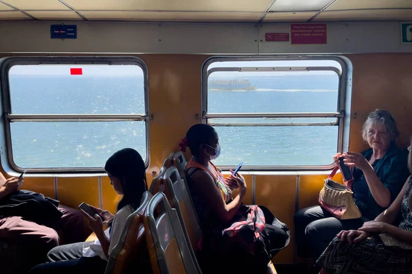 リスボンのツアーで渡し船の中の窓のそばに座っている観光客 — ストック写真