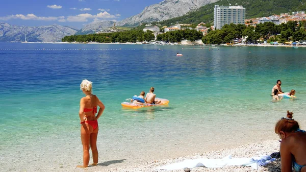 Sahilde beyaz bikinili genç bir kadın.