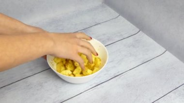 Yemek pişirmek. Patates, plaka 4K 'da bir kadın eliyle karıştırılmış.