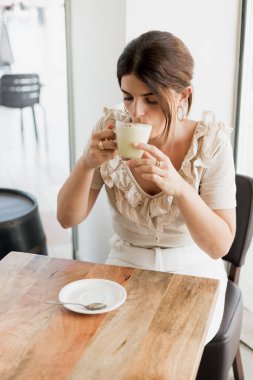 Kafede çay içen genç bir kadın.