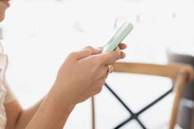 Kadının elleri telefon tutuyor.