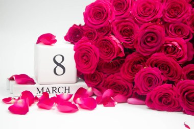 8 Mart 'ta, dağınık gül yaprakları ve bir buket gülle ahşap beyaz bir takvimde. konsept tatiller uluslararası kadınlar günü kartpostalı 
