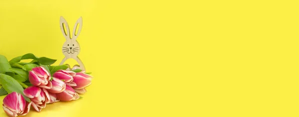 黄色の背景にキャンディで木製のイースターバニーとショッピングカート｜バナー — ストック写真