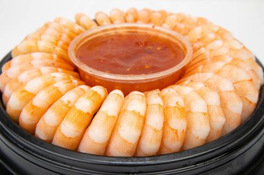 Deniz ürünleri, haşlanmış karides, plastik bir tabakta güzelce uzanmak, ve ortadaki sos..