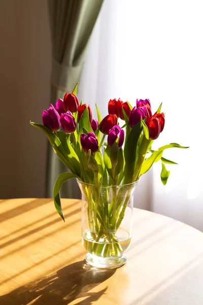チューリップとテーブルの上のガラス花瓶 窓や影からの光 テキストのための場所 ロマンチックな 誕生日 ロマンス 良い朝 母の日 3月8日 バレンタインデーの概念 — ストック写真