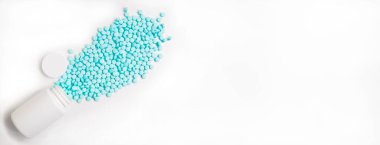 Pankart. Mavi haplar beyaz arka planda beyaz bir kavanozdan dağılıyor. İlaç, hap, vitamin, sağlıklı yaşam tarzı, hastalık, hastane, eczane, sanatoryum, tedavi.