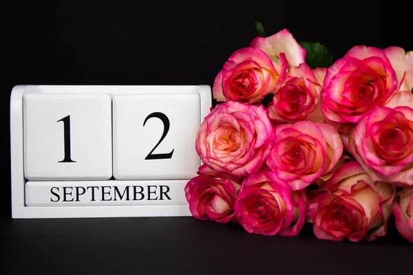Сентября Деревянный Календарь Белый Черном Фоне Розовые Розы Лежат Рядом — стоковое фото
