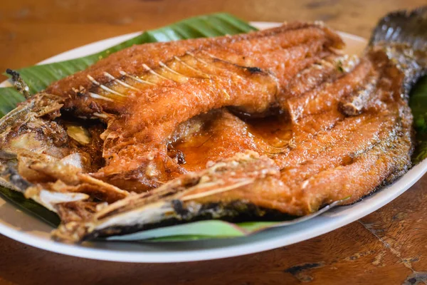 Tabakta kızarmış balık ve ahşap kaplama.